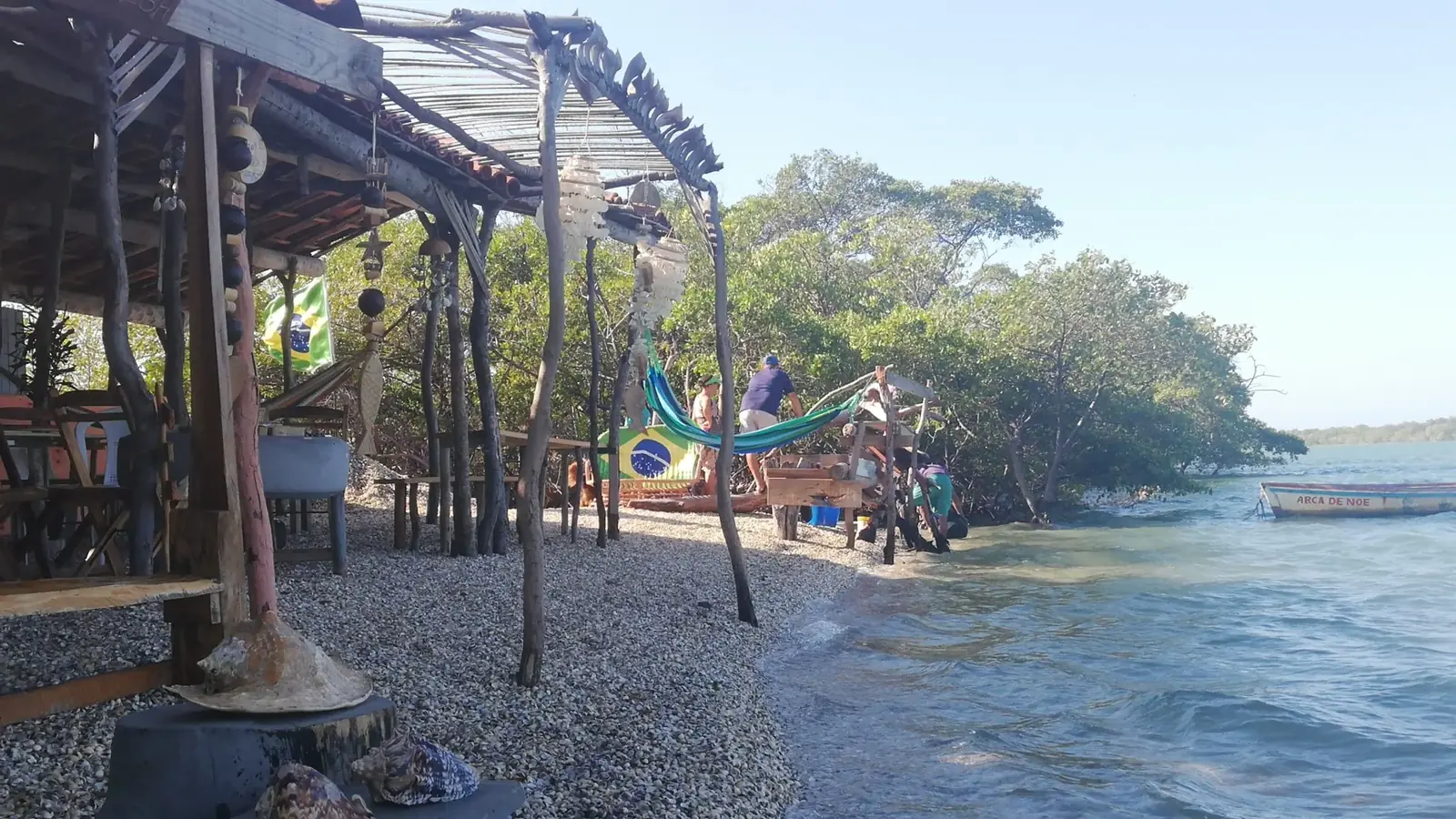 Estruturas rústicas e margem de conchas junto ao rio, onde trabalham as marisqueiras